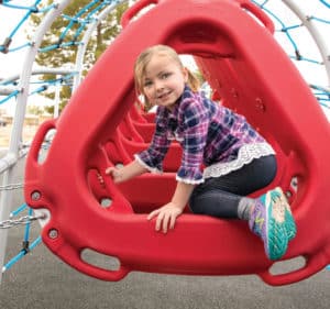 girl climbing on red playground accessory