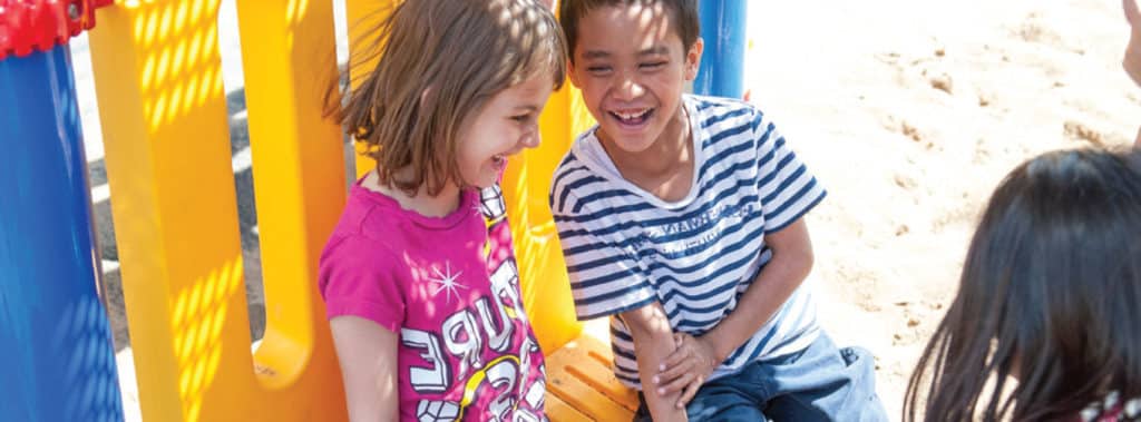 two children giggling on playground
