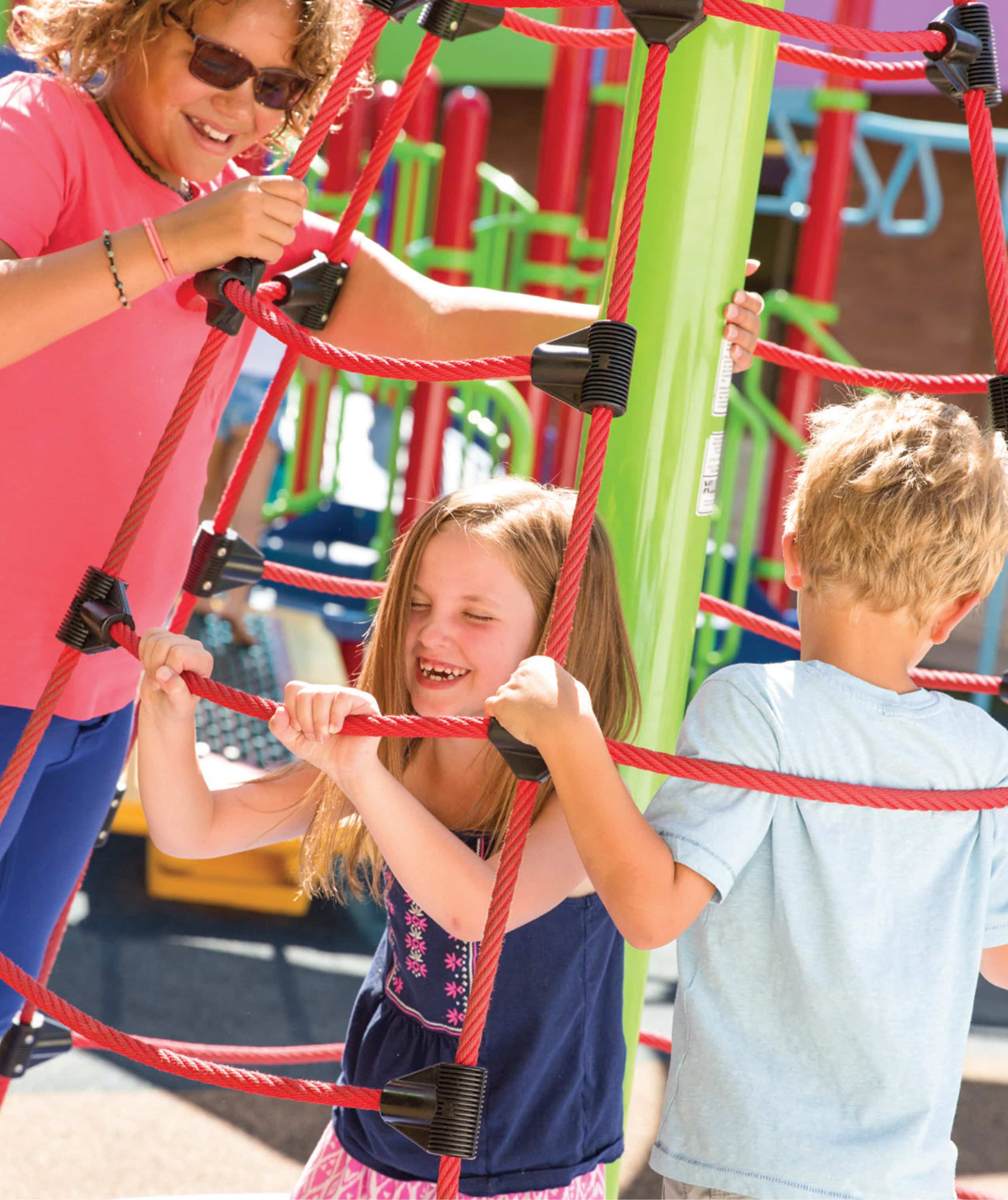 girl climbing on red playground accessory